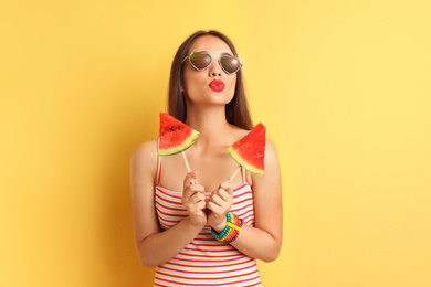 Image of Beautiful young woman posing with watermelon on color background