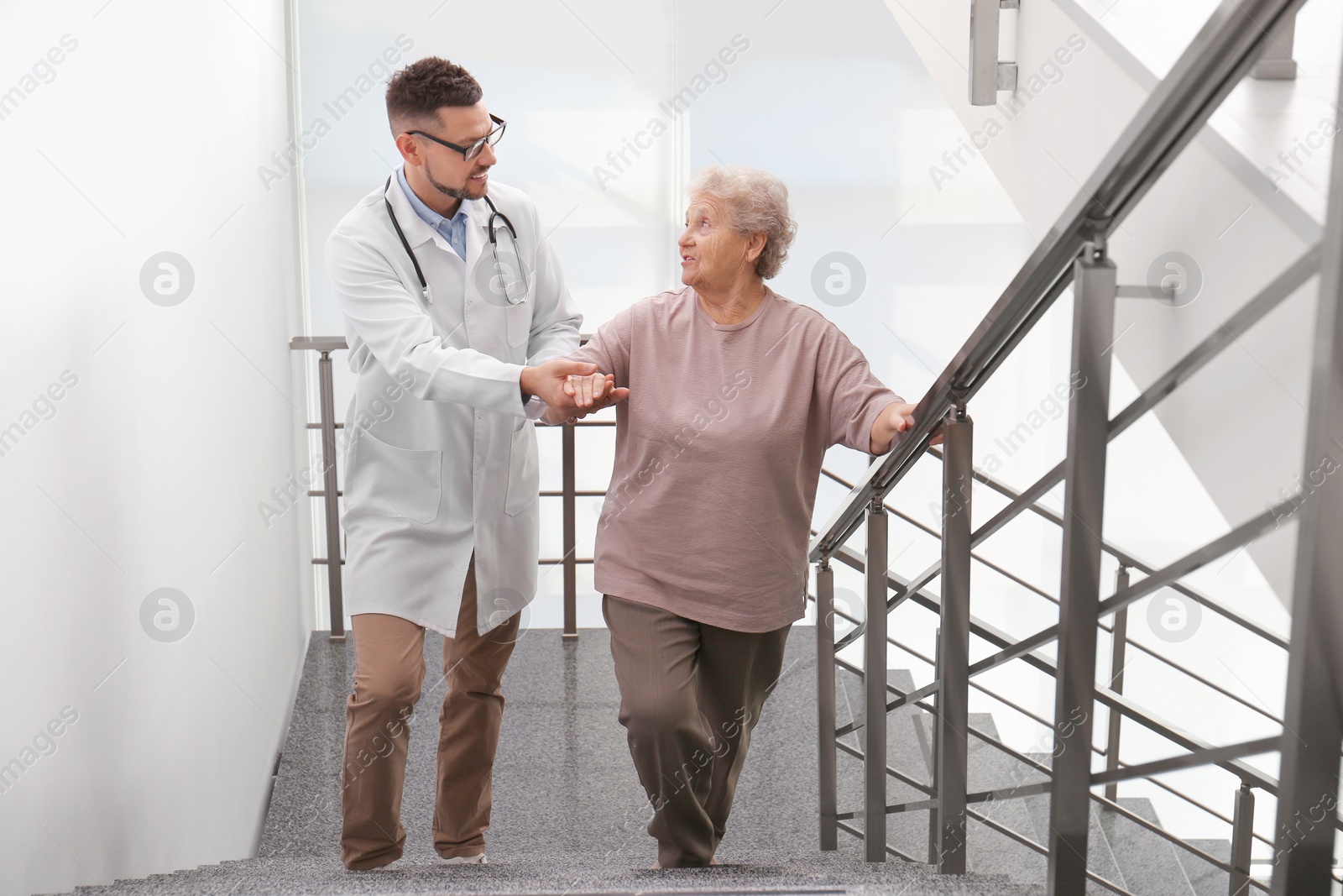 Photo of Doctor helping senior patient in modern hospital