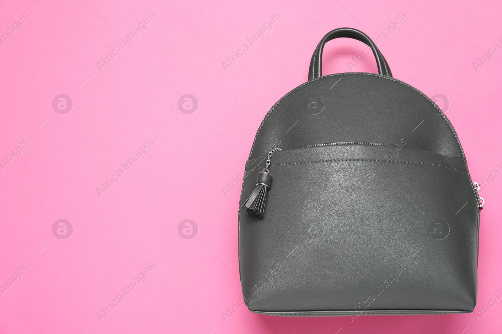 Photo of Stylish urban backpack on pink background, top view. Space for text