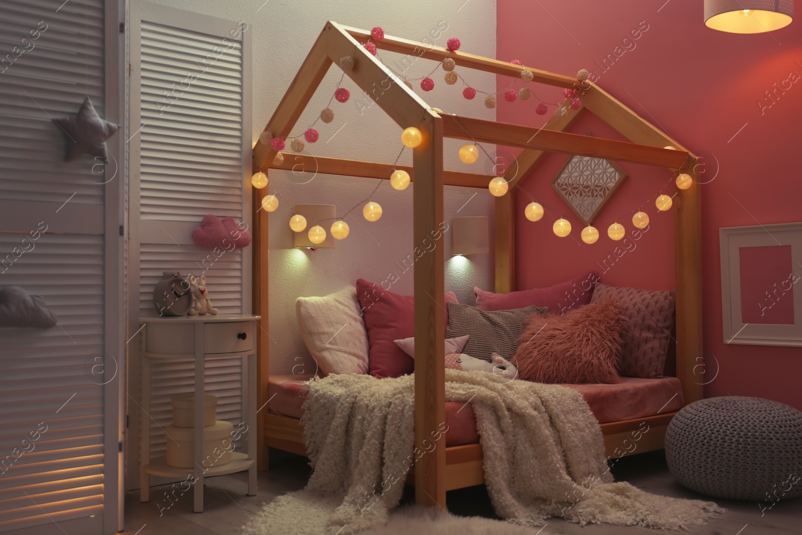 Photo of Child's room interior with comfortable bed and garland