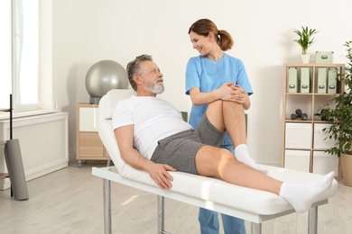 Physiotherapist working with patient in clinic. Rehabilitation therapy