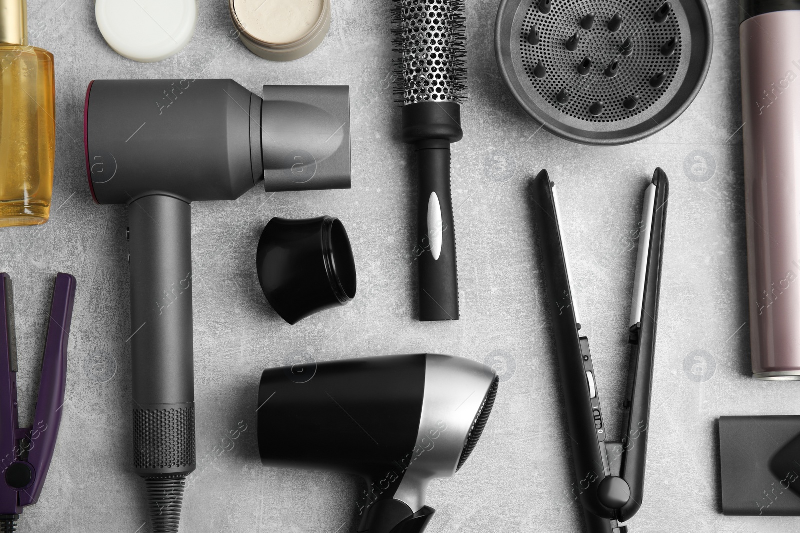 Photo of Flat lay composition with hairdressing equipment on grey stone background