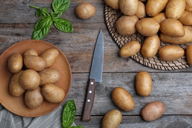 Flat lay composition with fresh ripe organic potatoes on wooden background