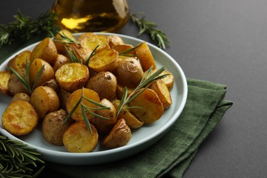 Delicious baked potatoes with rosemary on plate, closeup