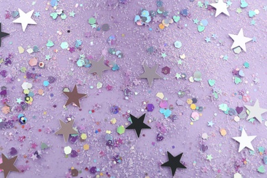 Photo of Shiny glitter on lilac background, flat lay