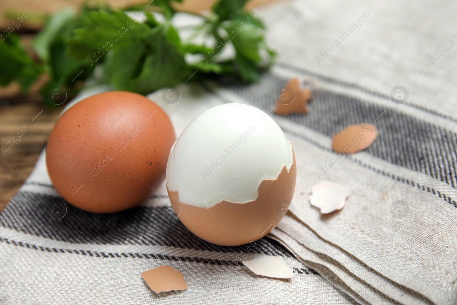 Photo of Boiled eggs and pieces of shell on kitchen towel, closeup