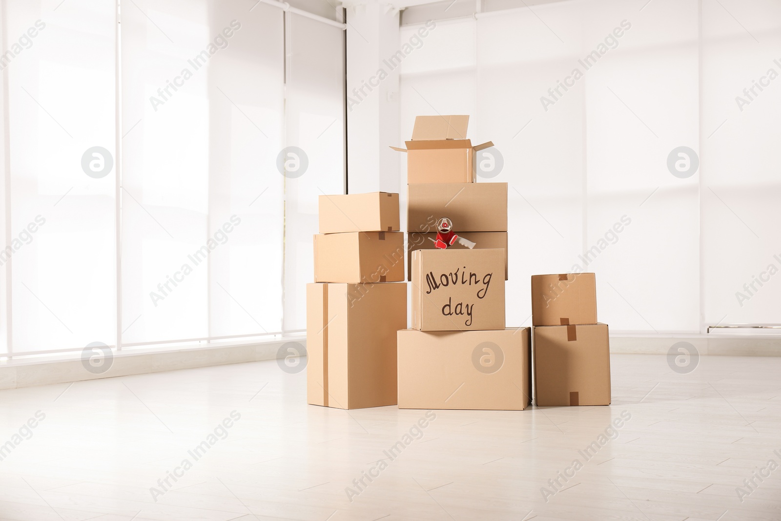 Photo of Pile of moving boxes in empty room