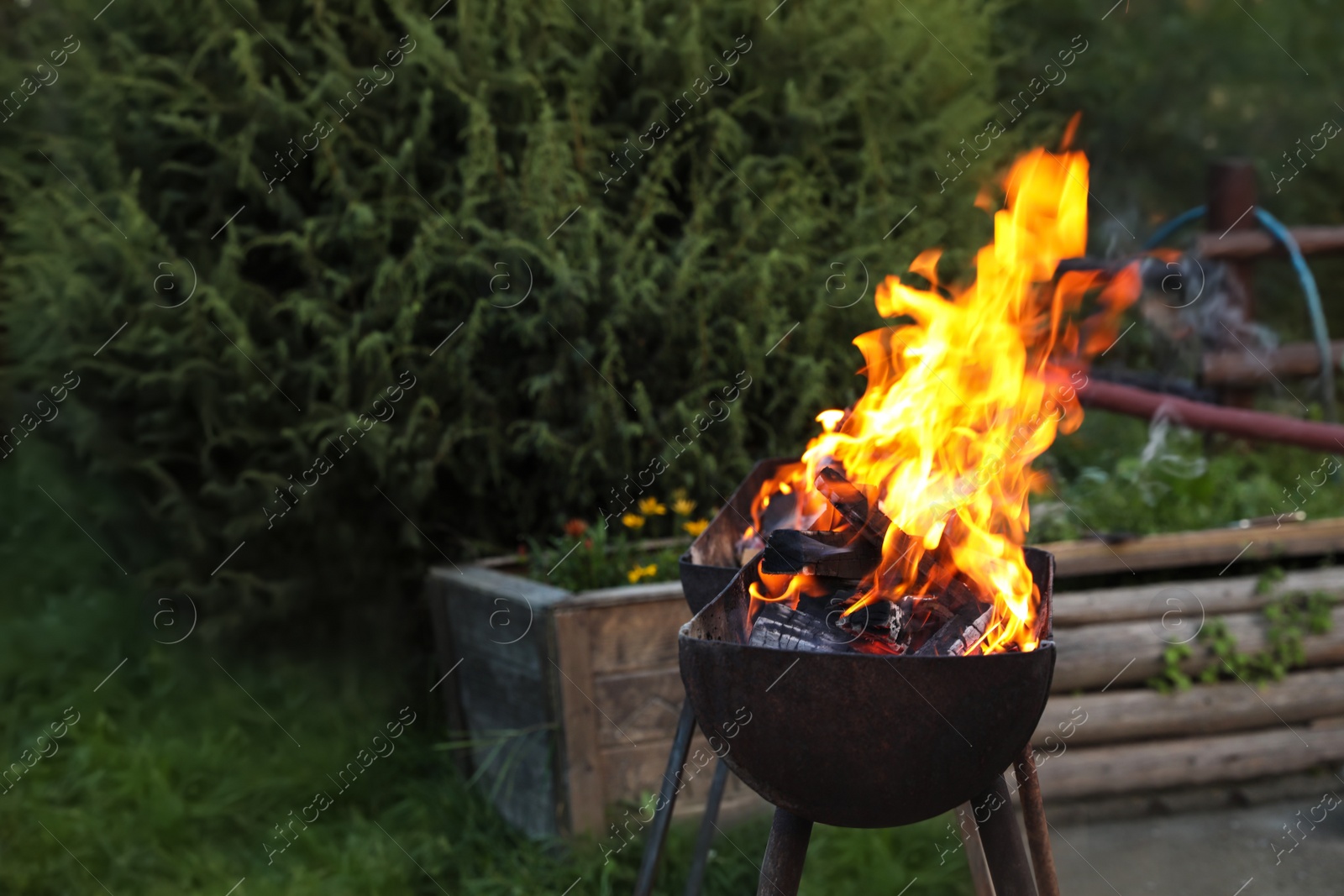 Photo of Barbecue grill with burning firewood outdoors. Space for text