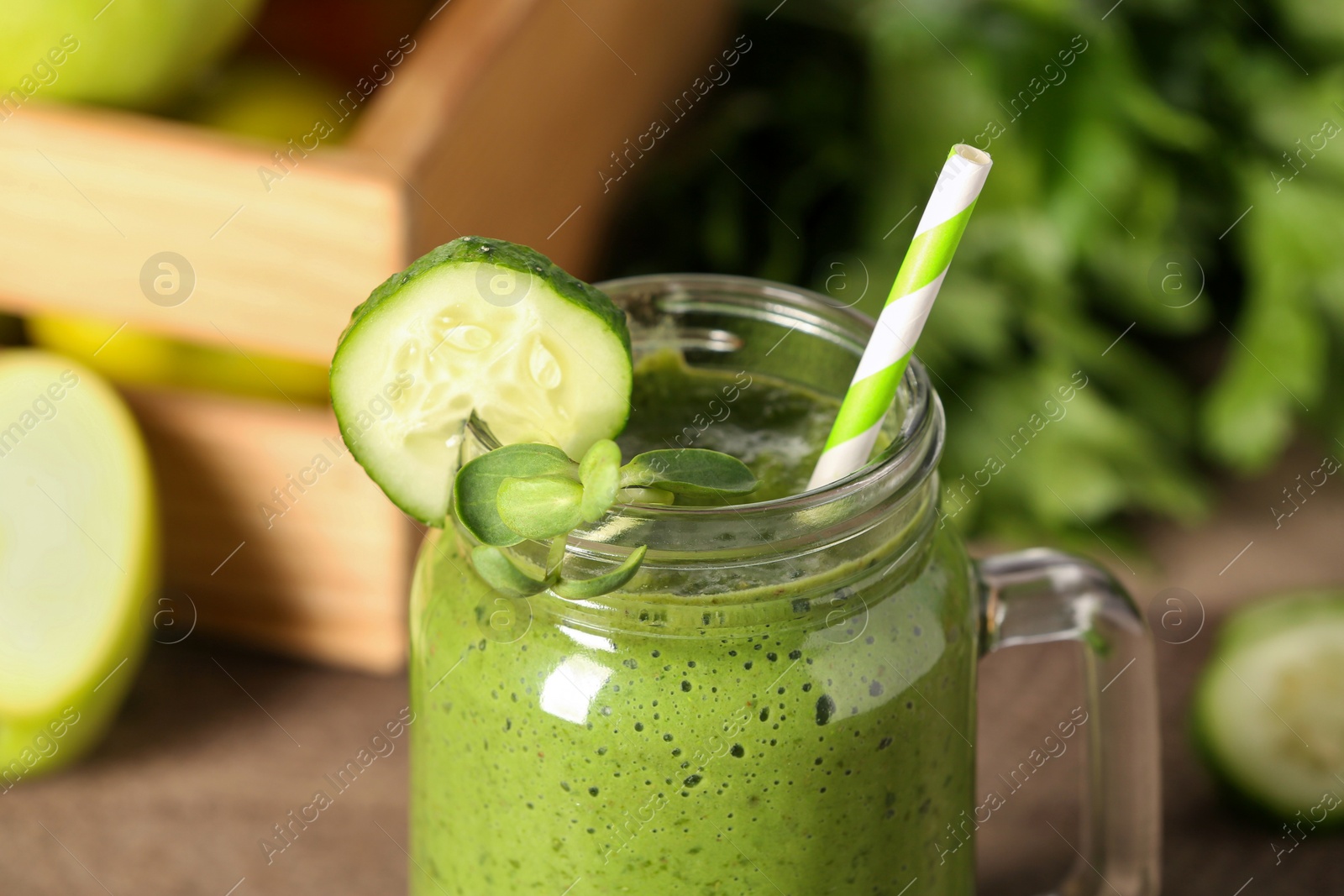 Photo of Fresh green smoothie and ingredients on wooden table, closeup