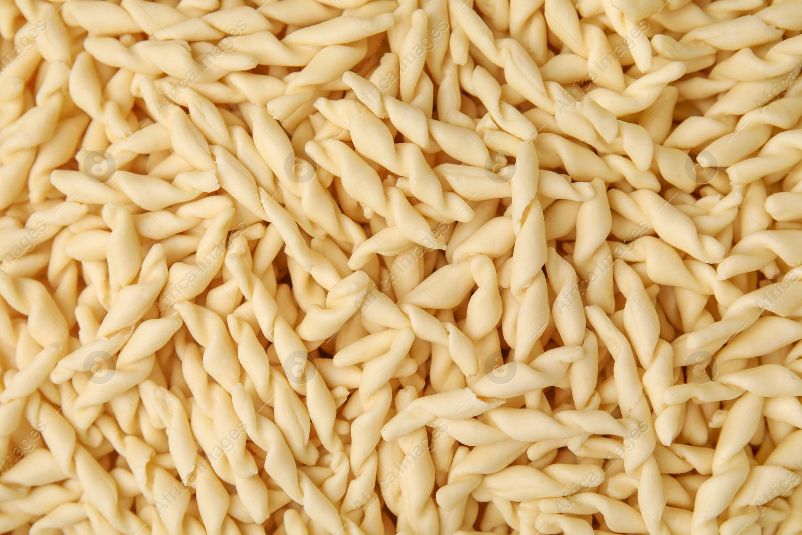 Photo of Uncooked trofie pasta as background, top view