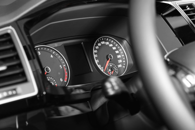 Photo of Wheel and dashboard in modern car, closeup view