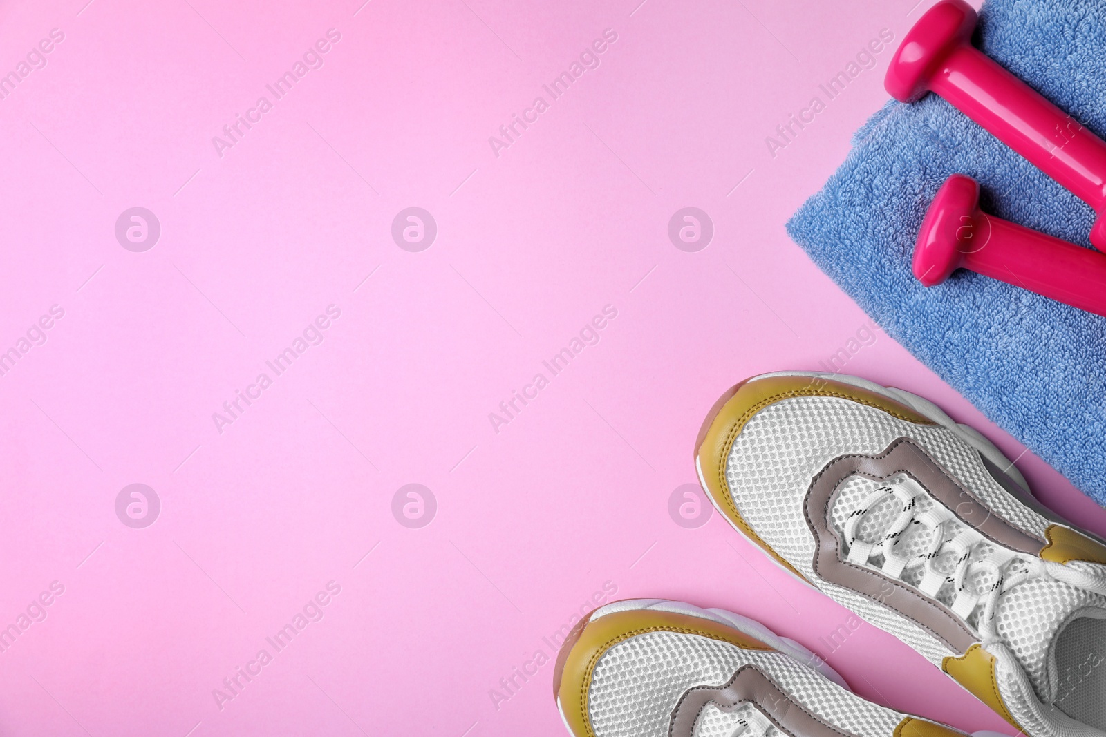 Photo of Flat lay composition with dumbbells, sneakers, towel and space for text on color background. Home fitness