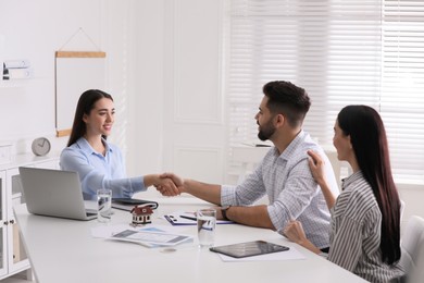 Photo of Real estate agent shaking hands with client in office. Mortgage concept