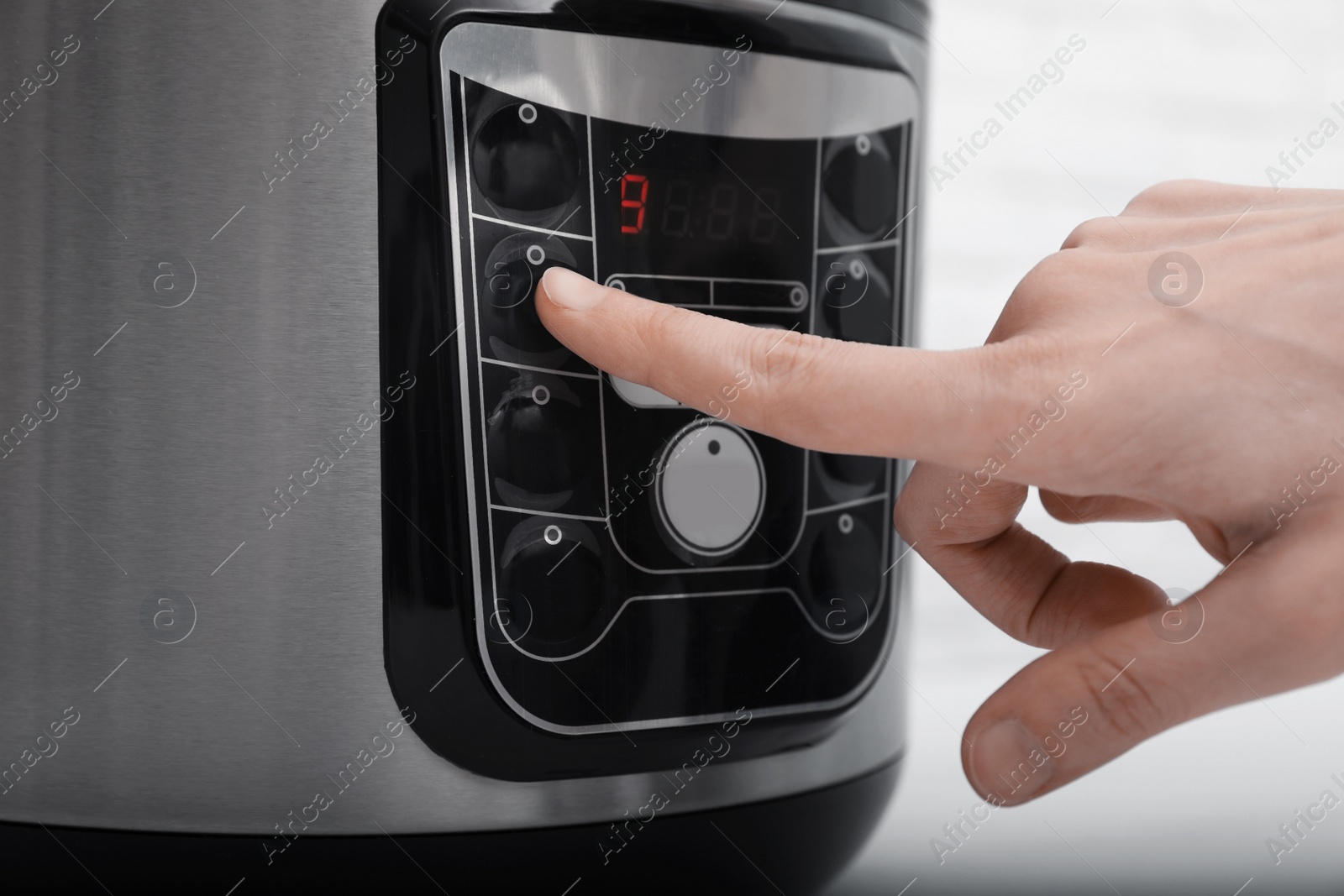 Photo of Woman turning on modern electric multi cooker, closeup