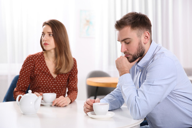 Couple with relationship problems at table in cafe