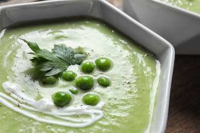 Photo of Fresh vegetable detox soup made of green peas in dish, closeup