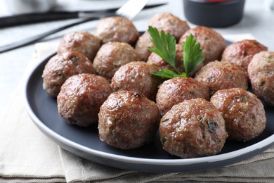 Photo of Tasty cooked meatballs with parsley on table, closeup