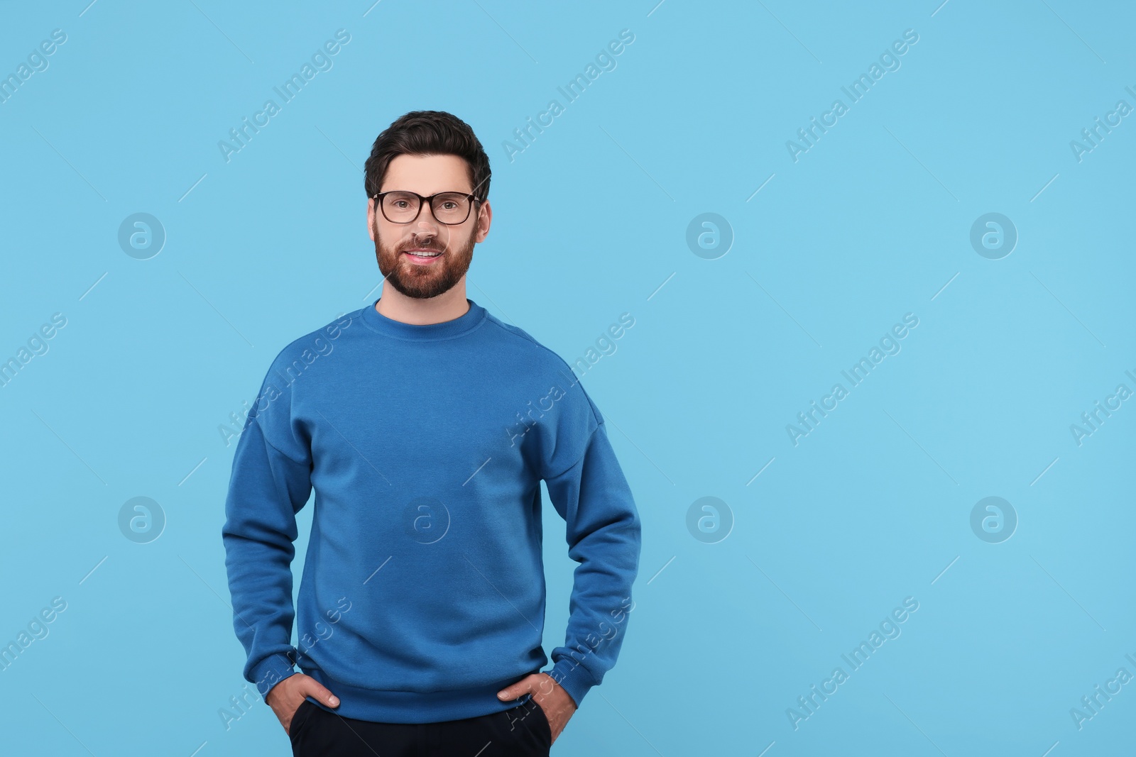 Photo of Portrait of handsome man in glasses on light blue background, space for text