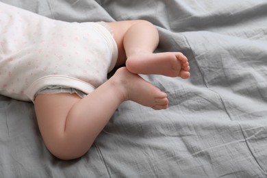 Photo of Little baby lying on bed, closeup view