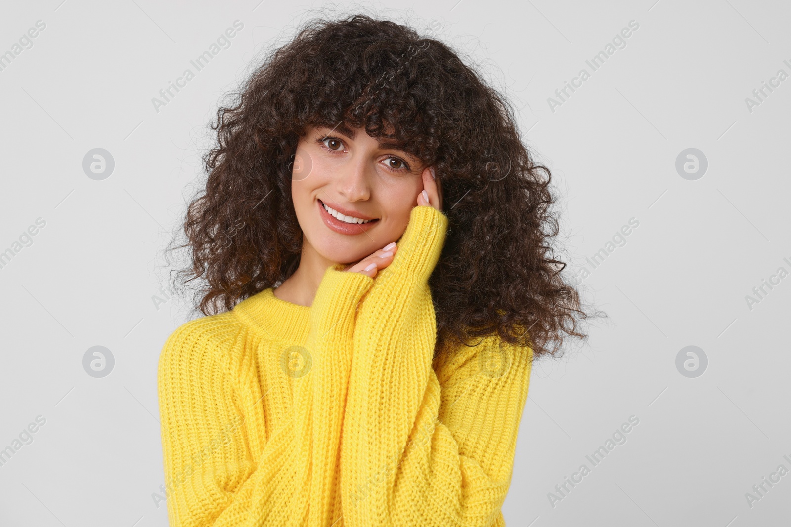 Photo of Happy young woman in stylish yellow sweater on white background