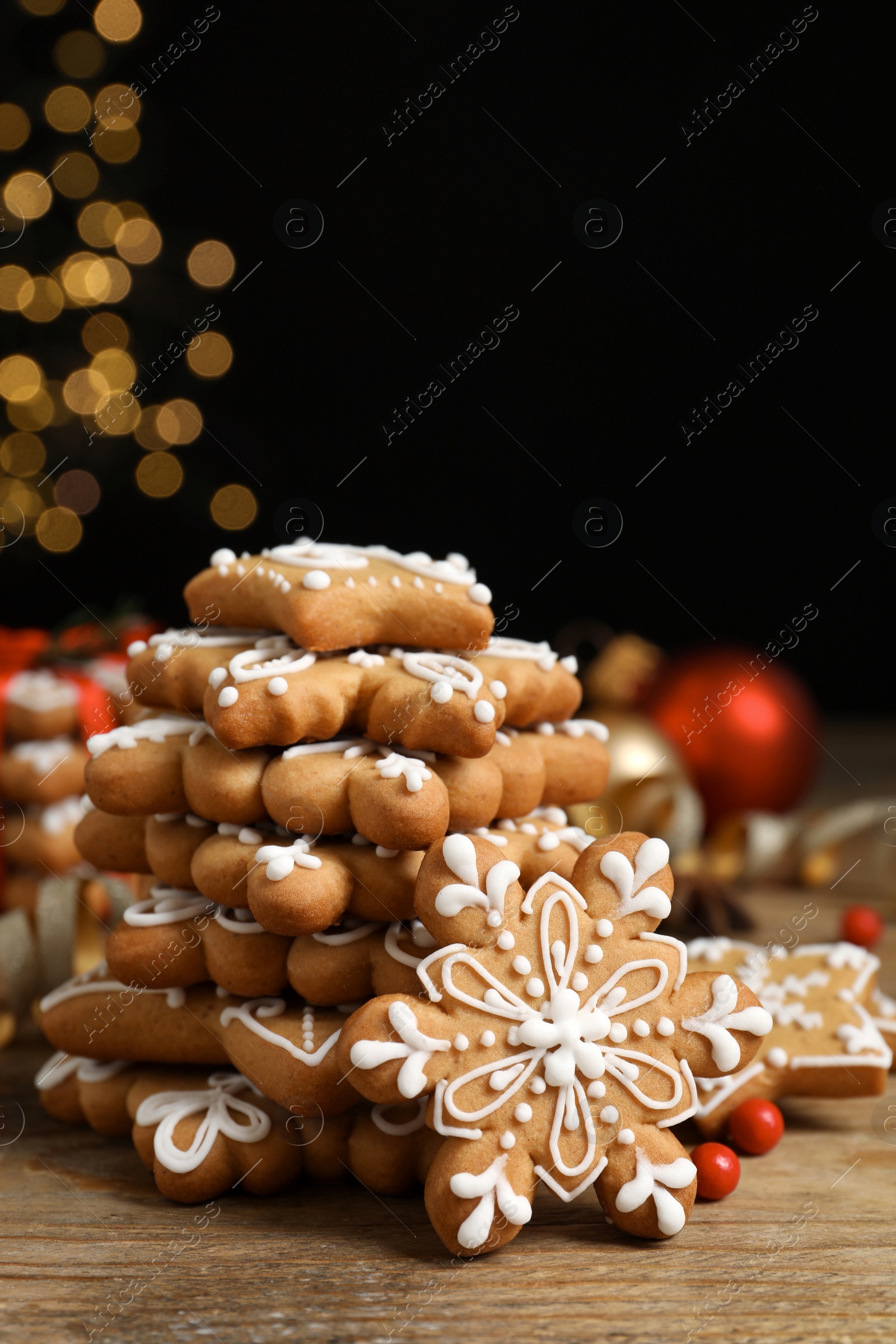 Photo of Tasty Christmas cookies on wooden table against blurred festive lights