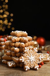 Tasty Christmas cookies on wooden table against blurred festive lights