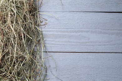 Photo of Heap of dried hay on grey wooden table, top view. Space for text