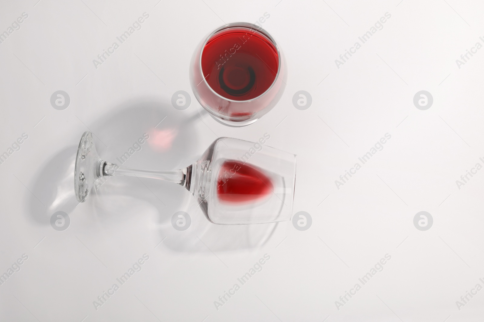 Photo of Tasty red wine in glasses isolated on white, top view