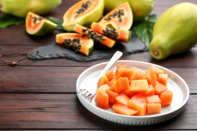 Diced fresh ripe papaya on wooden table