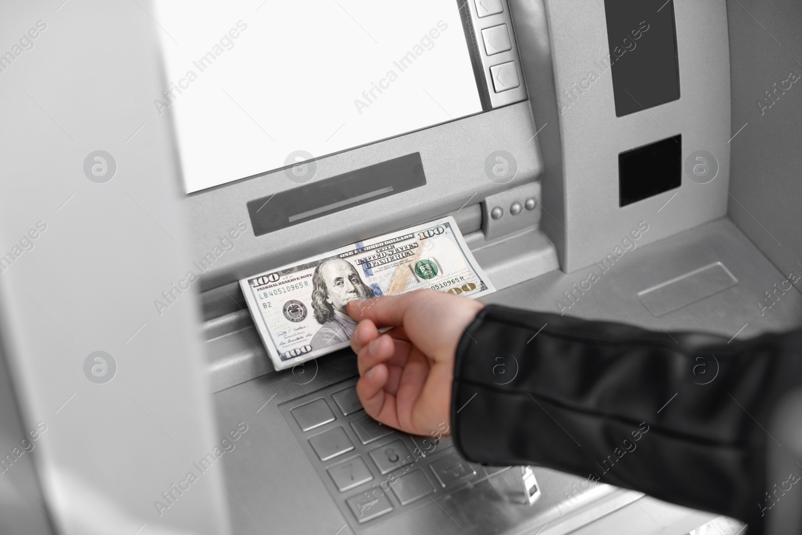 Photo of Man taking money from cash machine outdoors, closeup view