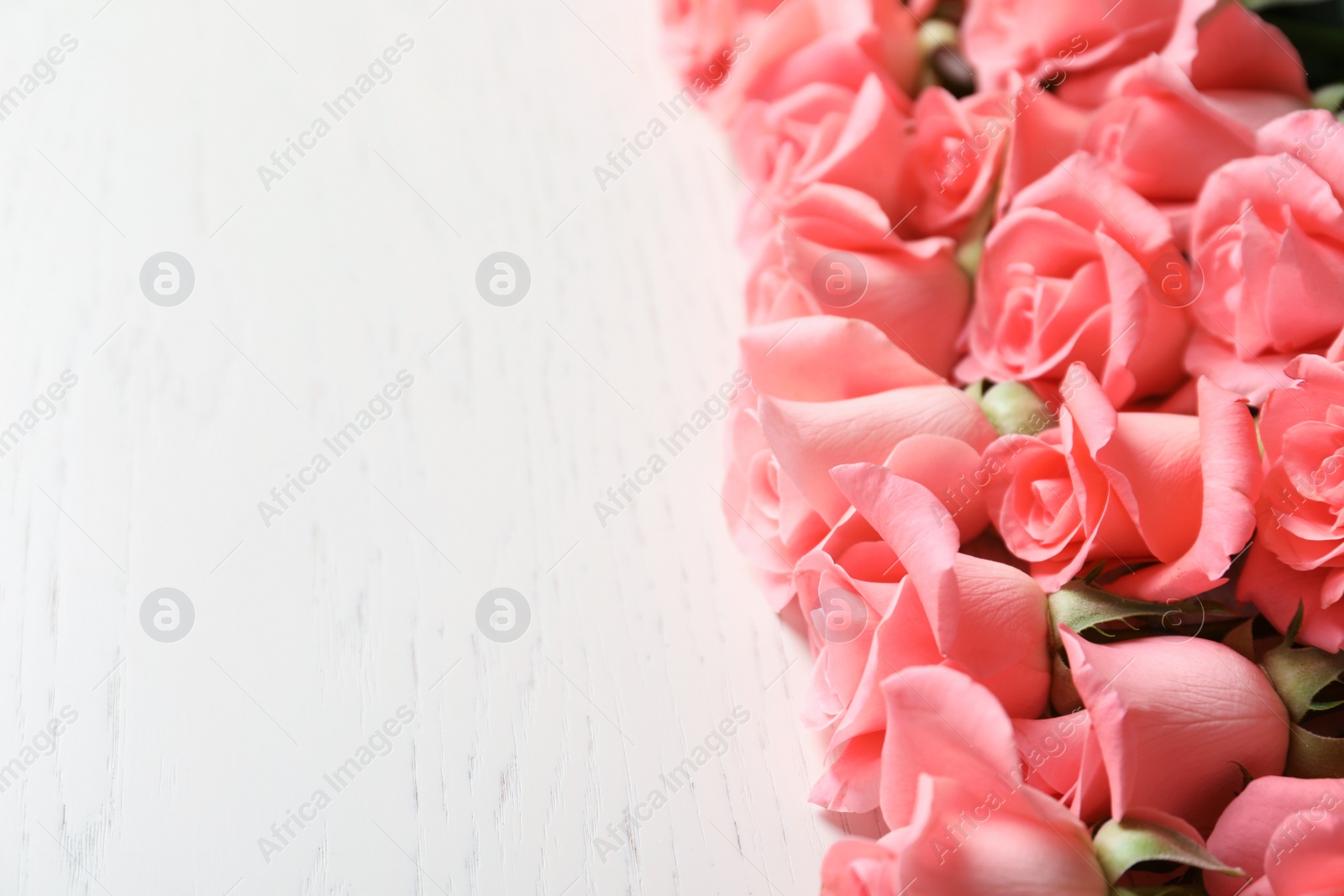 Photo of Beautiful roses on wooden table