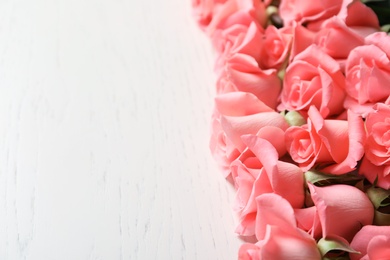 Photo of Beautiful roses on wooden table