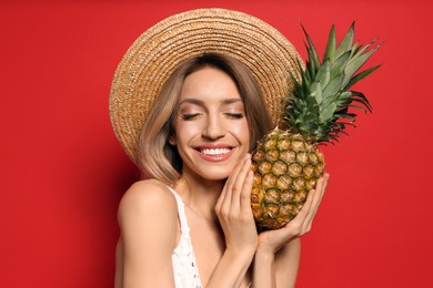 Young woman with fresh pineapple on red background. Exotic fruit