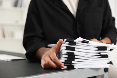 Man with documents at table in office, closeup