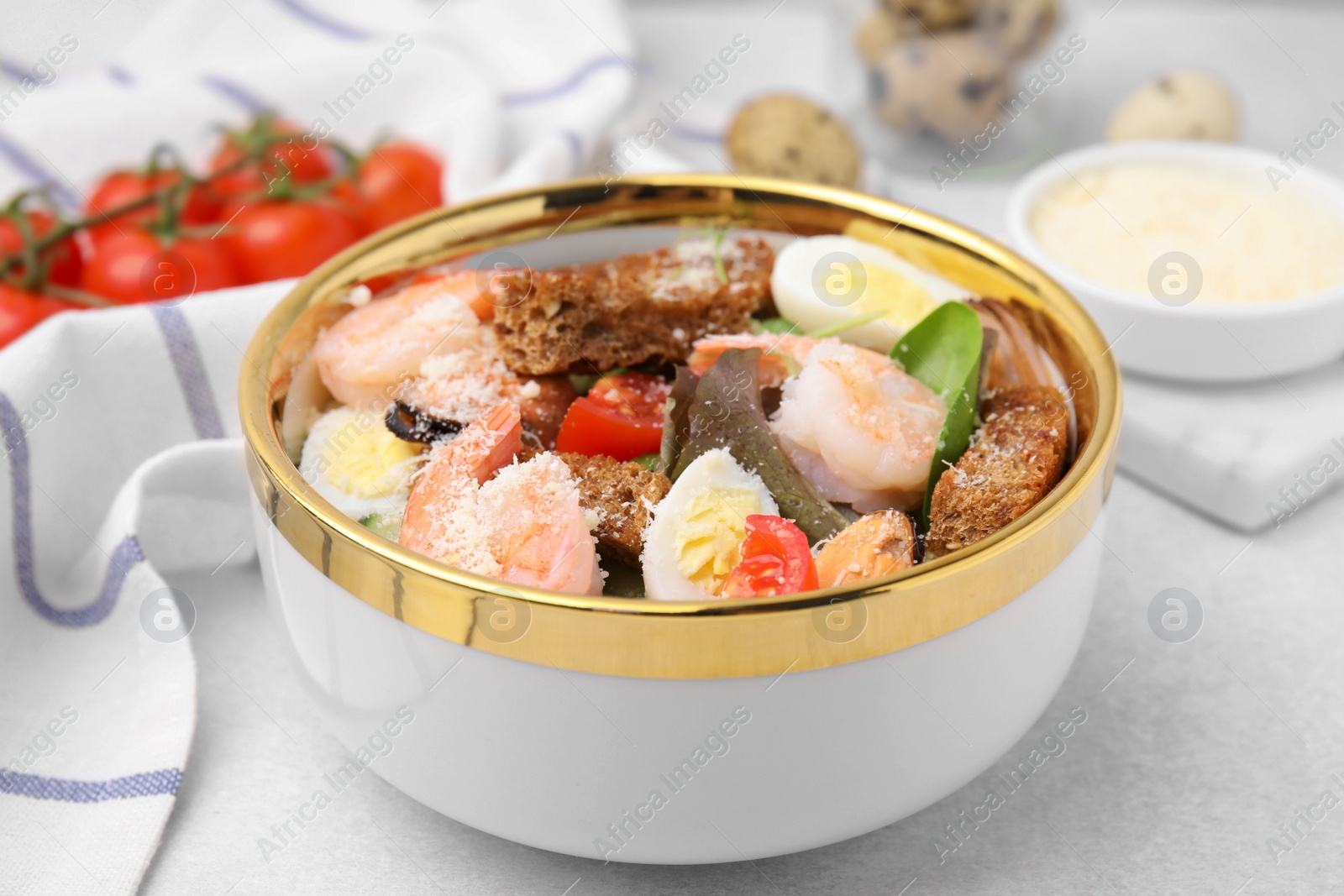 Photo of Delicious salad with croutons, tomatoes and shrimp served on white table, closeup