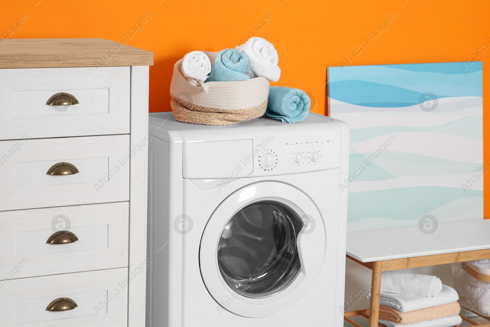 Photo of Stylish laundry room with washing machine. Interior design