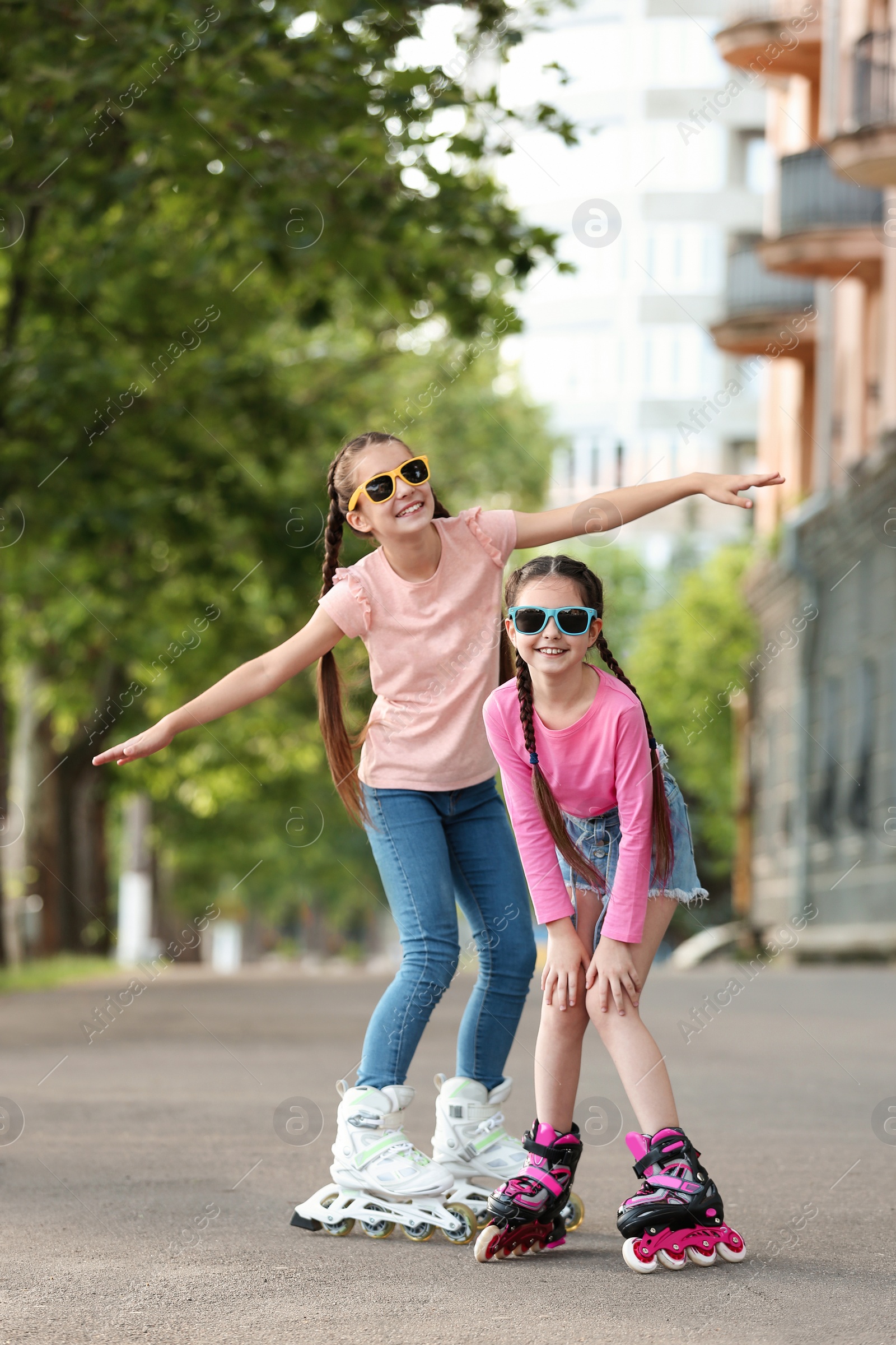 Photo of Little children roller skating on city street