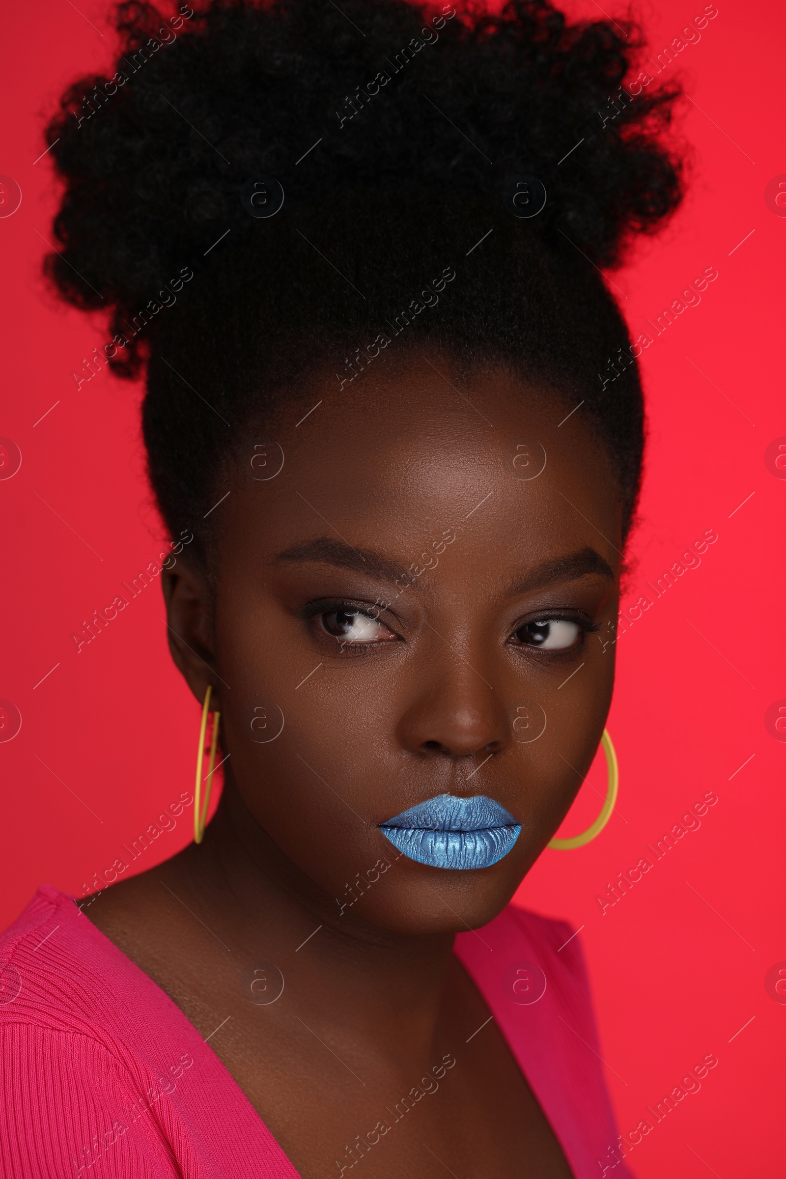 Photo of Fashionable portrait of beautiful woman with bright makeup on coral background