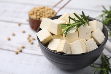 Photo of Delicious tofu cheese, rosemary and soybeans on white wooden table, closeup