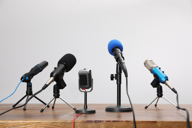 Photo of Set of different microphones on wooden table. Journalist's equipment