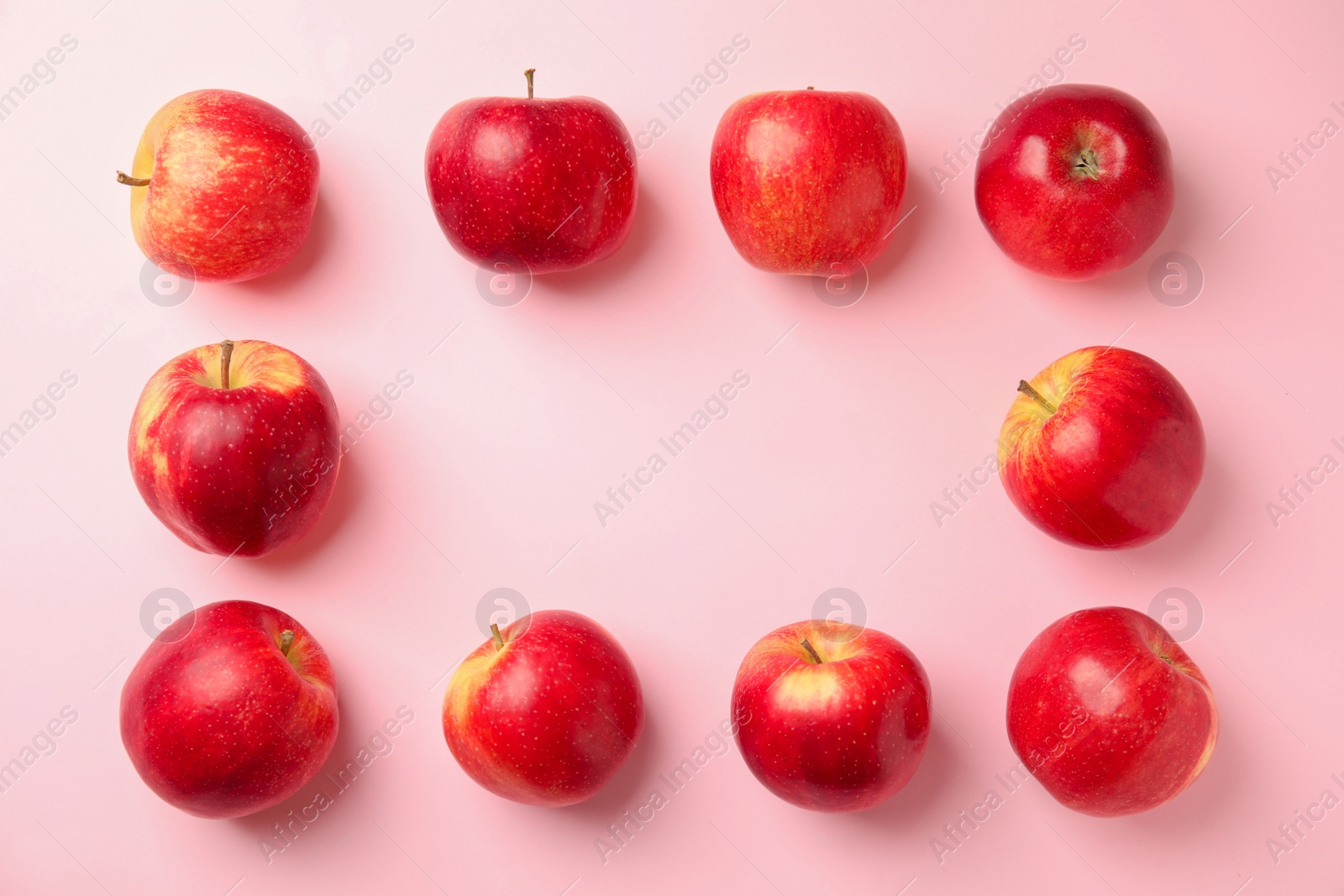 Photo of Frame made of fresh ripe red apples on pink background, flat lay. Space for text