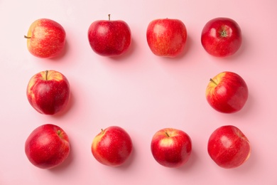 Frame made of fresh ripe red apples on pink background, flat lay. Space for text