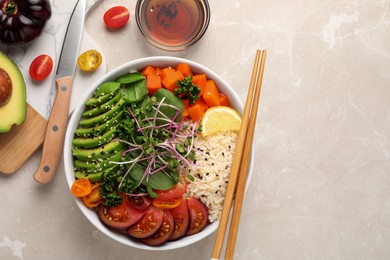 Delicious vegan bowl with avocados, carrots and tomatoes on light grey table, flat lay. Space for text