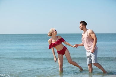 Photo of Happy young couple having fun at beach on sunny day