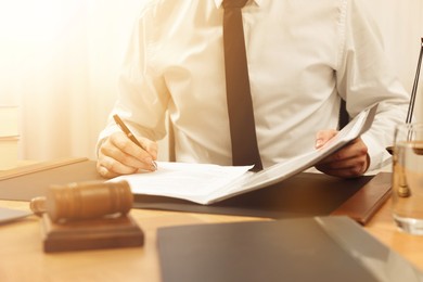 Image of Lawyer working with document at table indoors, closeup