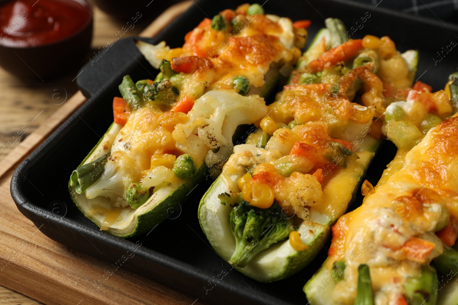 Photo of Baking dish with delicious stuffed zucchinis, closeup