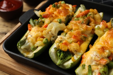 Photo of Baking dish with delicious stuffed zucchinis, closeup