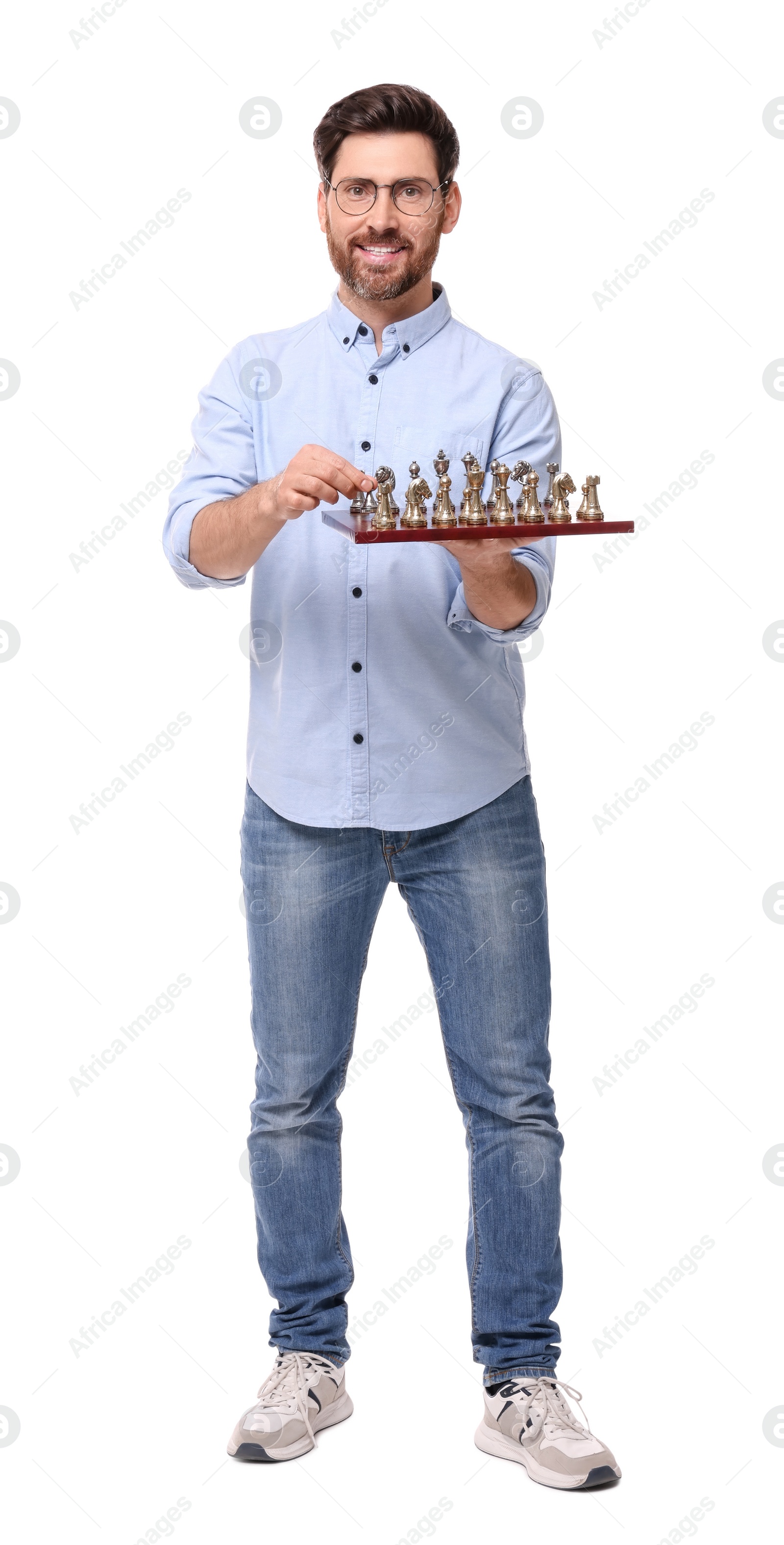 Photo of Smiling man holding chessboard with game pieces on white background