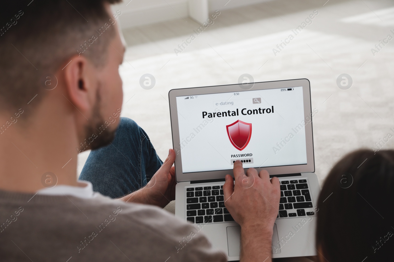 Photo of Dad installing parental control on laptop indoors, closeup. Child safety