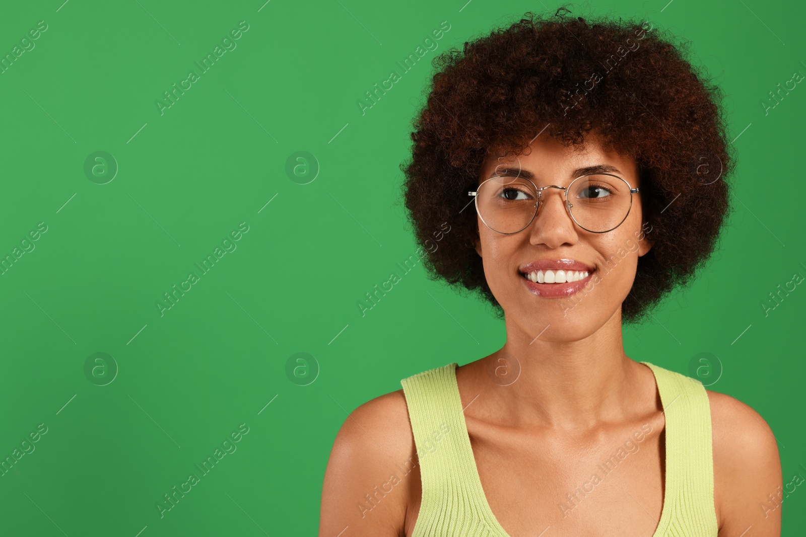 Photo of Portrait of happy young woman in eyeglasses on green background. Space for text